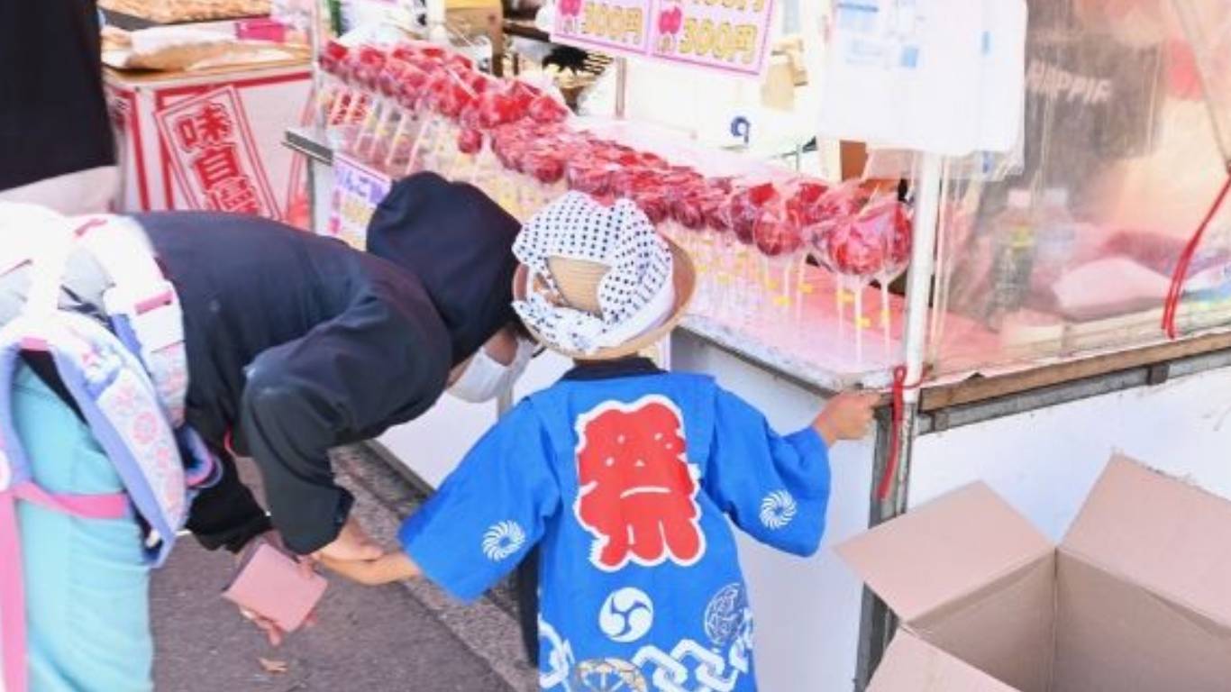 お祭りの屋台で遊ぶ子ども